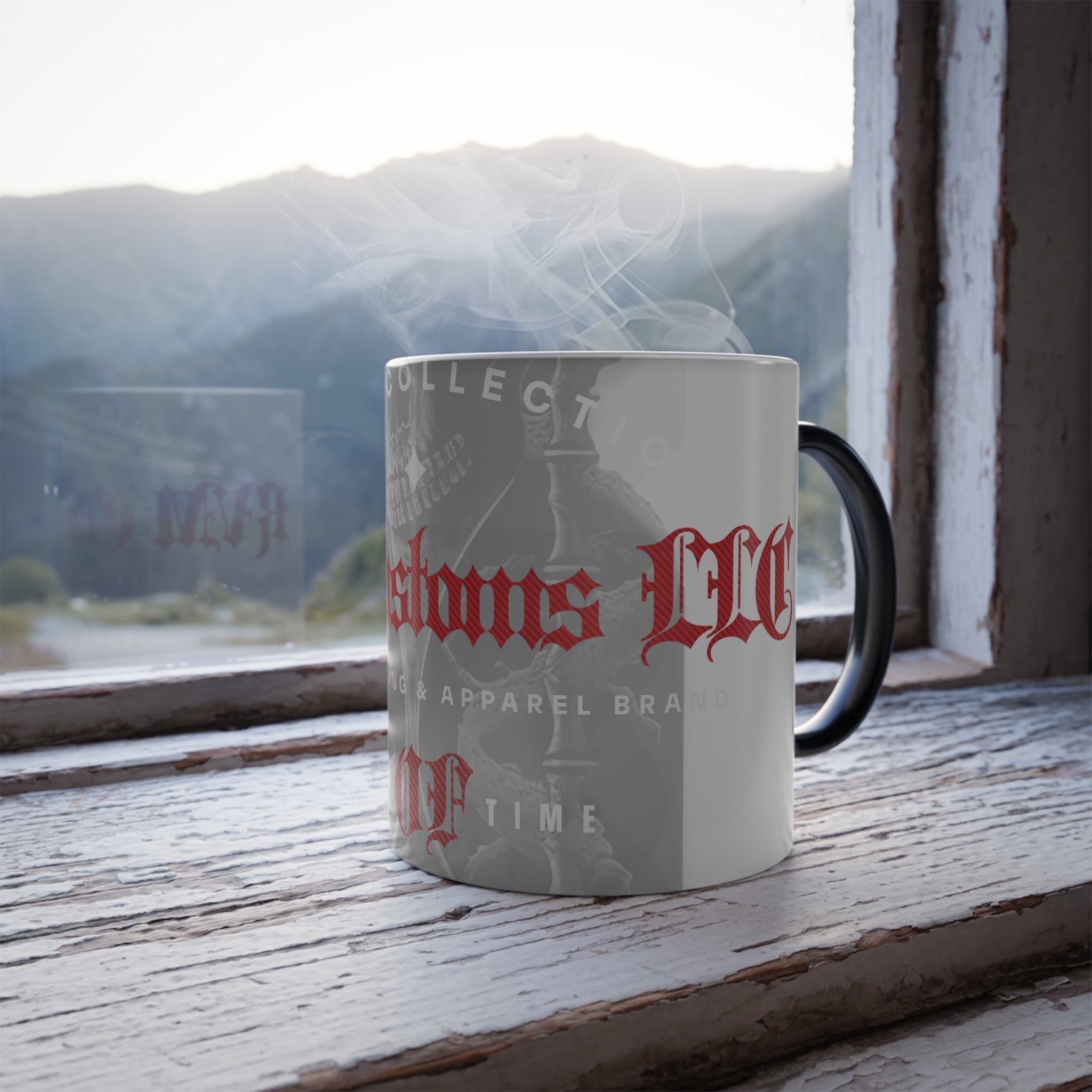 A Printify Color Morphing Mug, 11oz, with a white ceramic body and a black handle, rests on a rustic wooden windowsill. The personalized mug displays red and black text along with a design. Steam rises from its heat-reactive surface, suggesting a hot beverage inside. Through the window is a scenic mountain landscape under a cloudy sky.